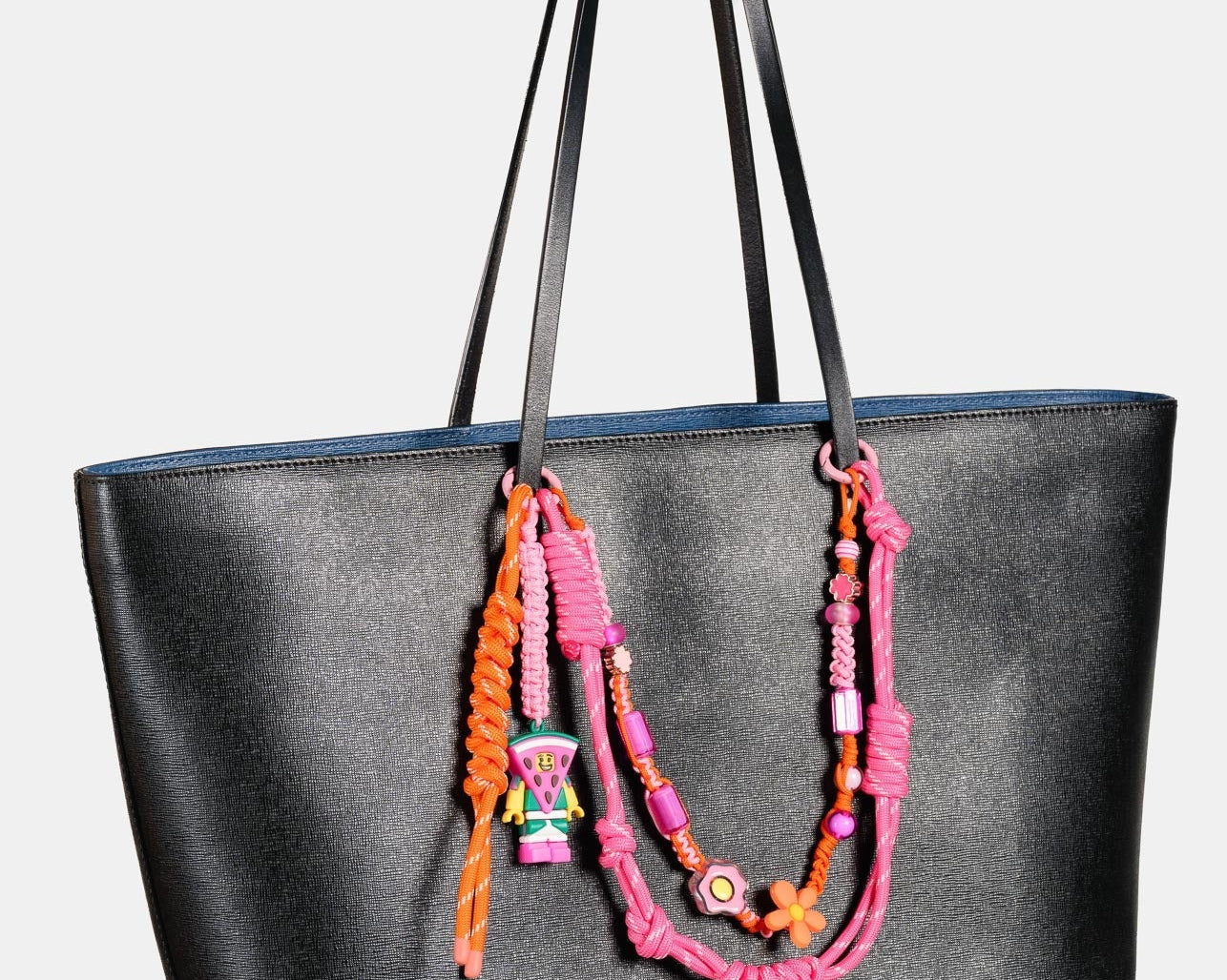 Handmade Happy-Nes bag charm styled on a handbag
