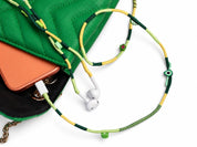 Botanica Beaded Lightning EarPods — handmade Apple Lightning earphones in lime, forest green and yellow with kiwi, leaf and evil-eye beads, styled with a green quilted bag
