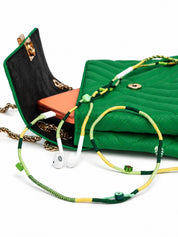 Botanica Beaded Lightning EarPods — handmade Apple Lightning earphones in lime, forest green and yellow with kiwi, leaf and evil-eye beads, styled with a green quilted bag – photo 2